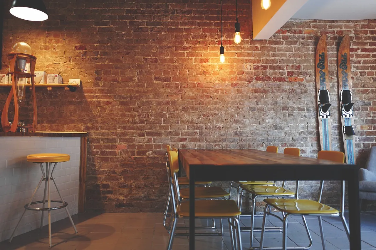 Warm brick dining room with timber tables and pendant lights